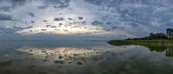 Scenic view of lake against sky at sunset