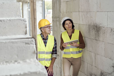 Engineer with tablet pc discussing with architect at site