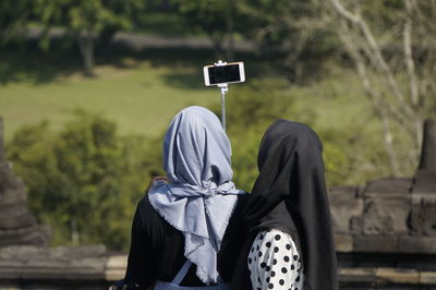 Rear view of women taking selfie