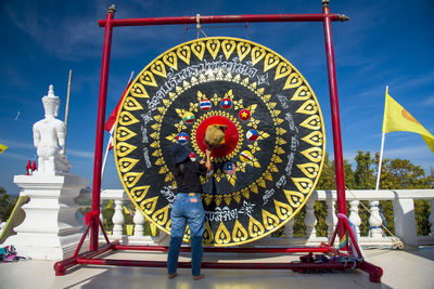 Low angle view of people standing against multi colored wall