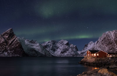 Aurora polaris over lake against sky at night