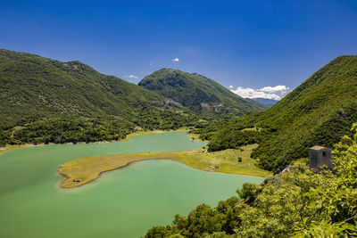 Scenic view of lake and mountains against clear sky