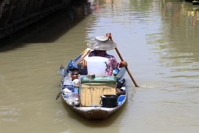 Rear view of market vendor in river