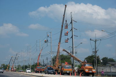 Cars on street in city against sky