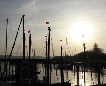 Sailboats on lake against sky during sunset