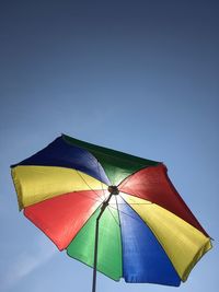 Low angle view of umbrella against blue sky