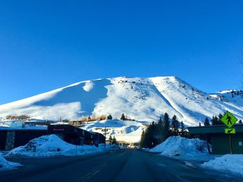 Snow covered mountain against clear blue sky