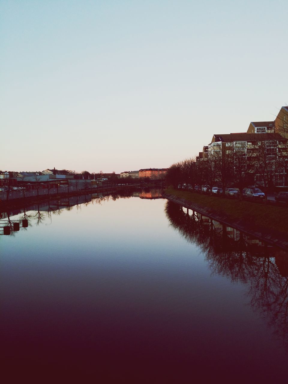 architecture, clear sky, built structure, water, building exterior, copy space, reflection, waterfront, river, city, canal, standing water, outdoors, lake, no people, connection, sunset, bridge - man made structure, tranquility, nature