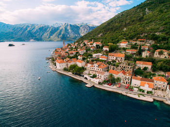 Aerial view of townscape by sea against sky