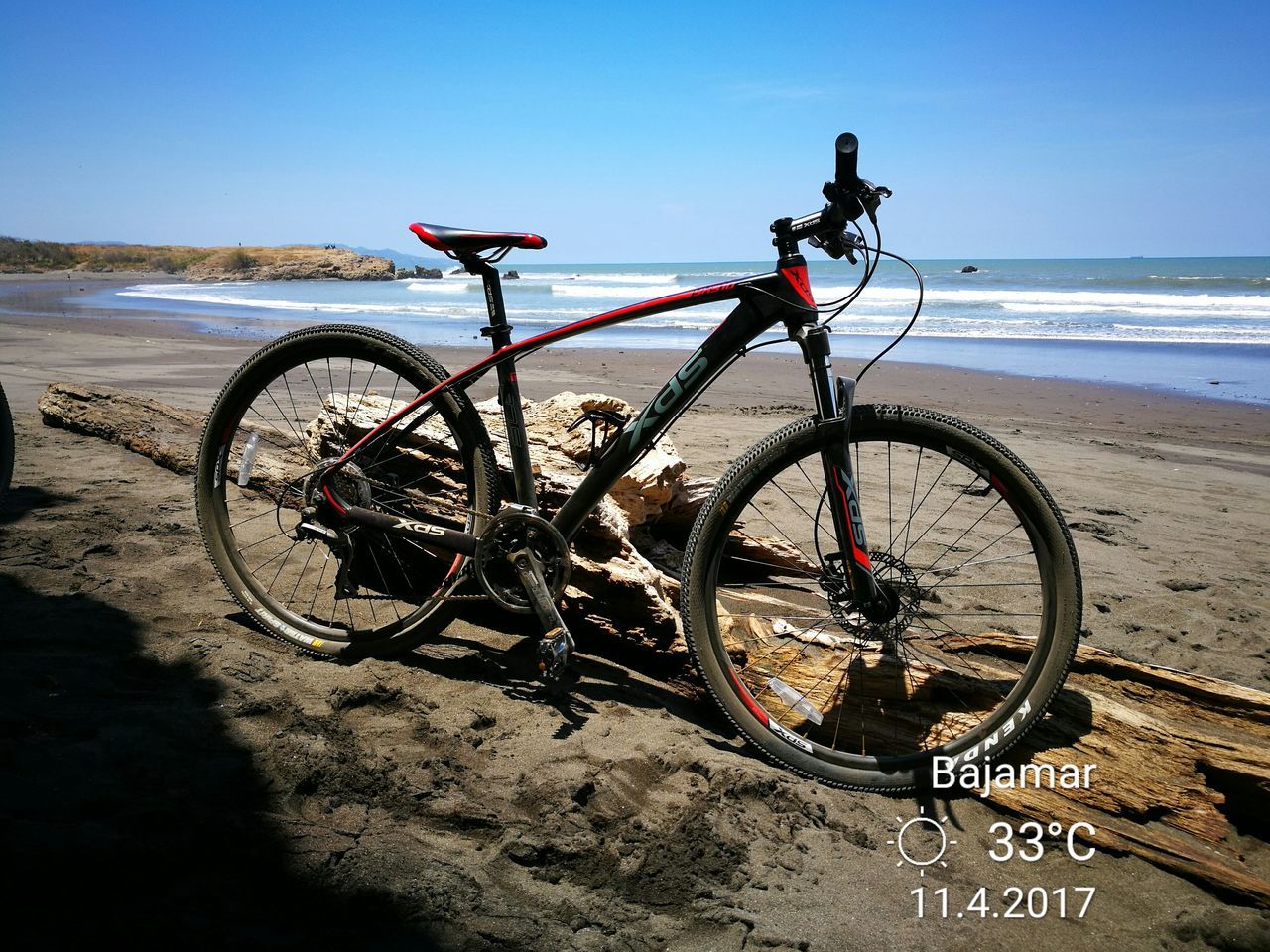 BICYCLE ON BEACH AGAINST SKY