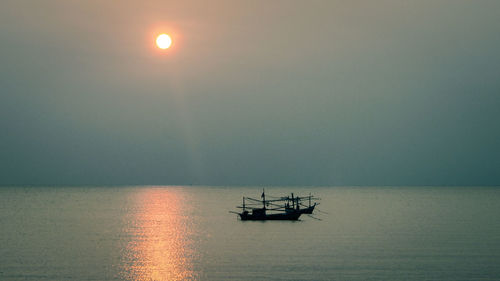 Boat sailing in sea at sunset