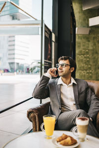 Young man looking at camera while sitting on table