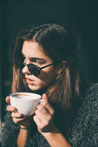 Close-up of woman drinking coffee in sunglasses