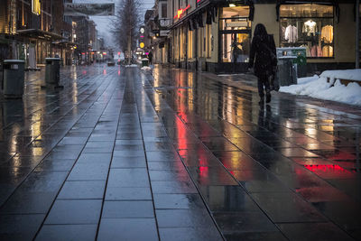 Wet walking in illuminated city at night