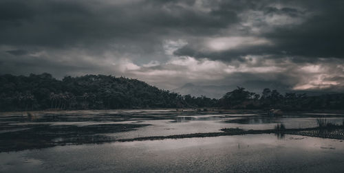 Scenic view of lake against cloudy sky