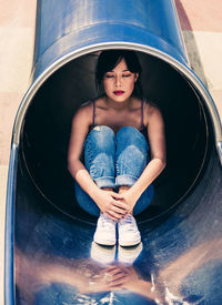 High angle portrait of young woman sitting outdoors