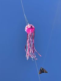 Low angle view of kite flying against clear blue sky