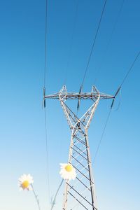 Low angle view of electricity pylon against blue sky