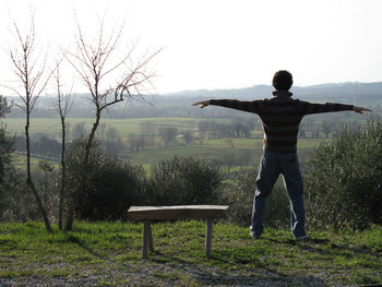 Rear view of man standing on riverbank