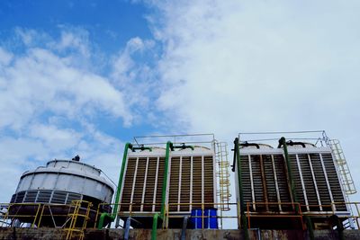 Low angle view of industrial against blue sky.