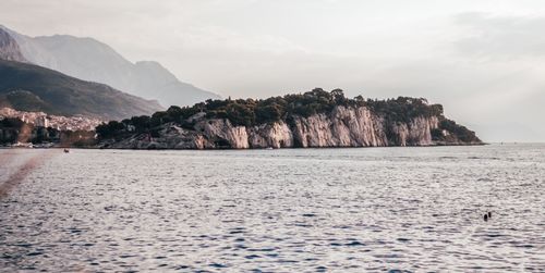 Scenic view of sea and mountains against sky