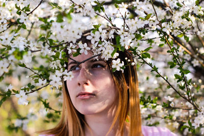 Close-up of thoughtful beautiful woman by tree