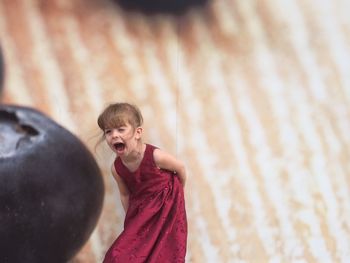 Cute girl shouting against poster