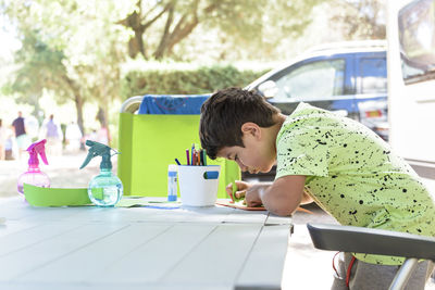 Primary school boy doing manual work while on vacation and preparing to go back to school.