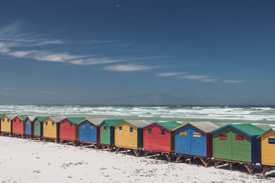 Beach umbrellas by sea against sky