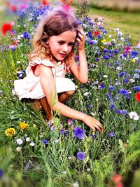 Portrait of woman with purple flowers on field