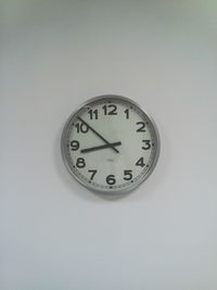 Close-up of clock on white wall