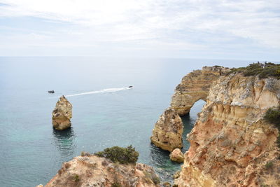 Scenic view of rocks in sea against sky