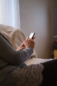 Midsection of woman using mobile phone at home