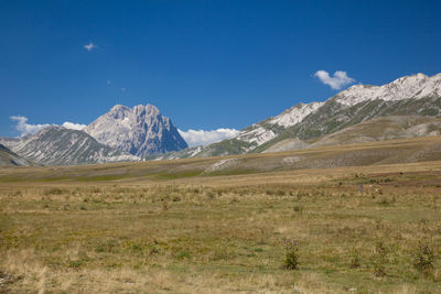 Scenic view of rocky mountains against blue sky