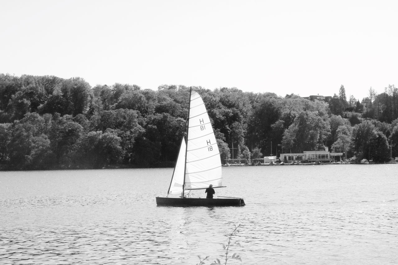 nautical vessel, water, tree, waterfront, plant, sailboat, sky, transportation, mode of transportation, sailing, day, lake, nature, clear sky, tranquility, canvas, beauty in nature, tranquil scene, incidental people, outdoors