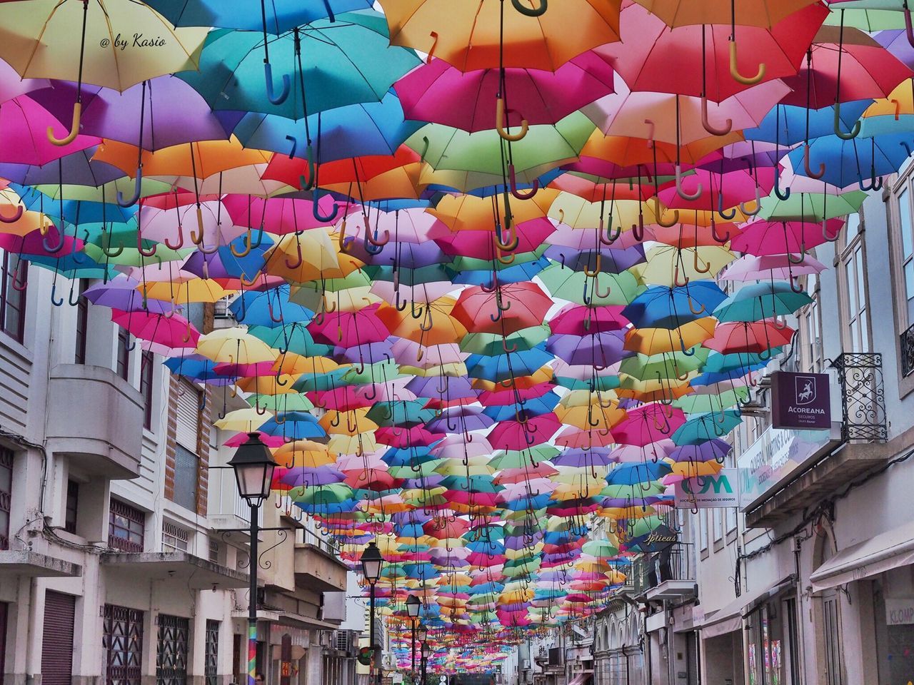 multi colored, hanging, architecture, built structure, building exterior, variation, large group of objects, low angle view, abundance, colorful, city, lantern, decoration, choice, outdoors, tourism, day, no people, cloud - sky, decorated