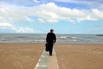 Rear view of a woman standing on beach