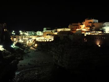 High angle view of illuminated houses against sky at night