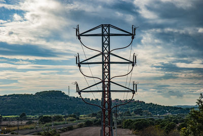 Low angle view of electricity pylon against sky