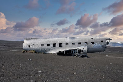 Abandoned damaged plane wreck at black sand beach in solheimasandur at sunset