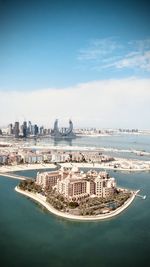 Aerial view of city buildings against cloudy sky