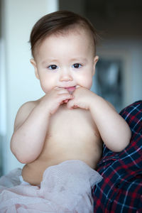 Portrait of shirtless baby girl at home