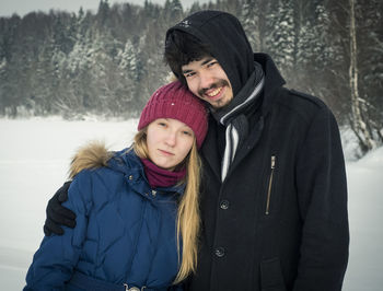 Portrait of smiling man and woman in snow