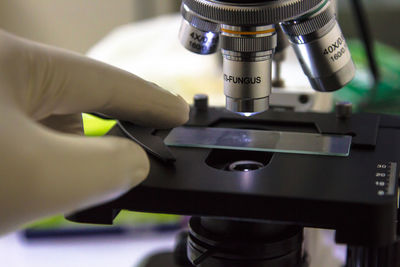 Cropped hand with microscope in laboratory