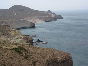 Scenic view of sea and mountains against sky