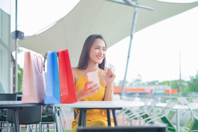 Young woman sitting on chair at table