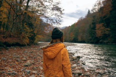 Woman standing by trees during autumn