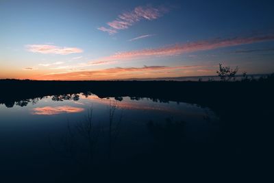 Scenic view of calm lake at sunset