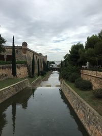 River by historic building against sky