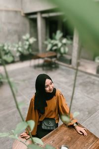 Portrait of young woman looking away while standing outdoors